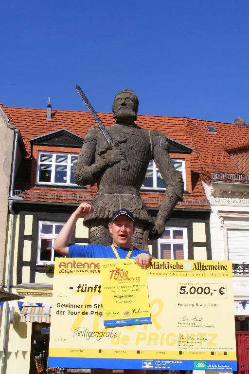 Gewinner Holger Kippenhahn - Bürgermeister Heiligengrabe - posiert mit dem Siegerscheck vor dem Roland auf dem Perleberger Marktplatz